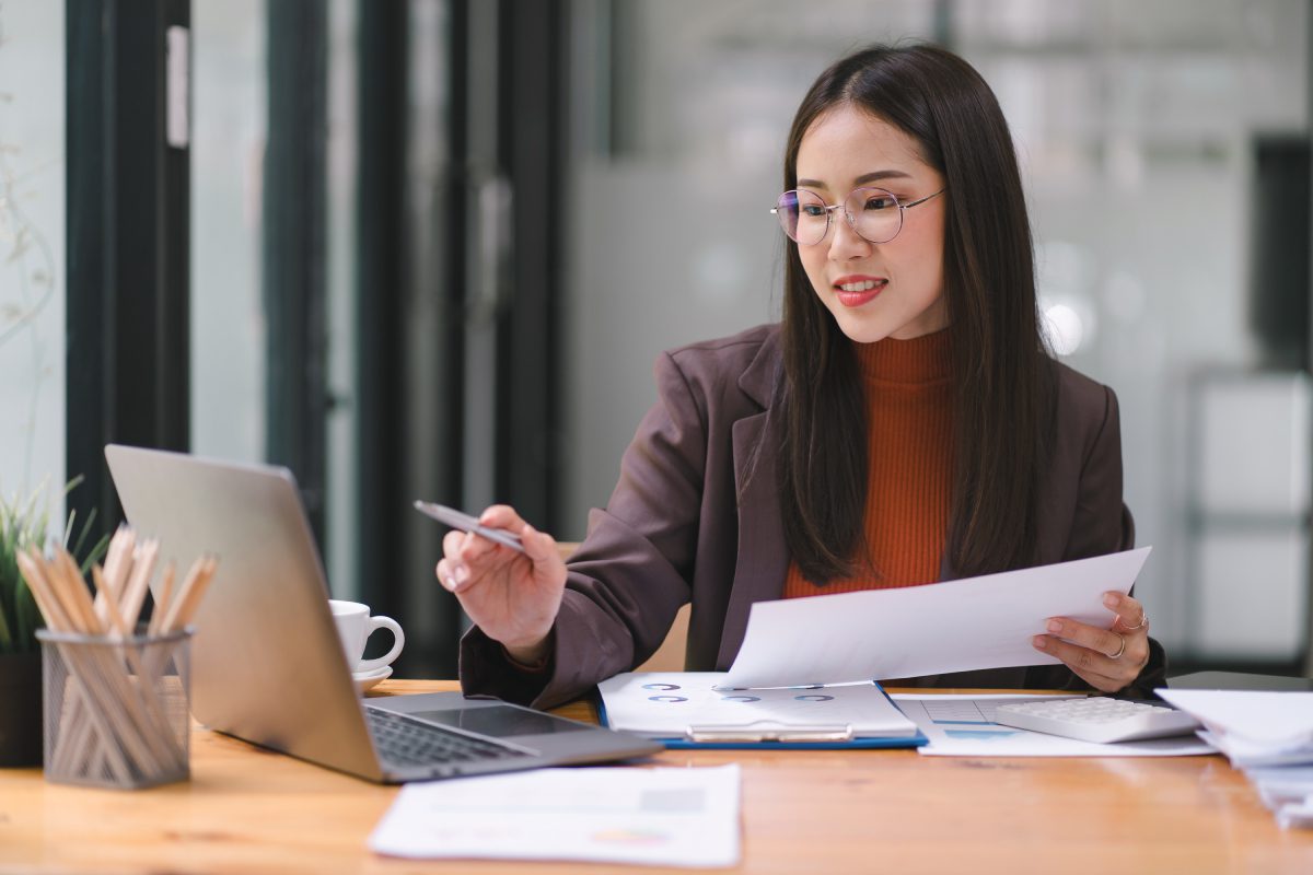 Businesswoman analyzing documents at her desk.